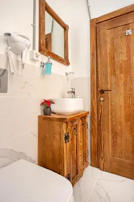 a bathroom with a sink and a wooden door at Armel Homes Galata in Istanbul