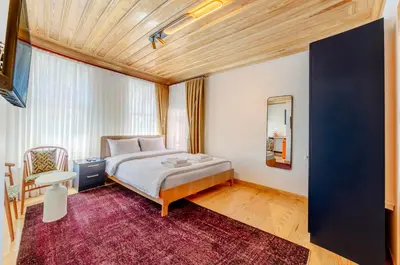 a bedroom with a bed and a chair and a mirror at Evra Suites Hotel in Istanbul