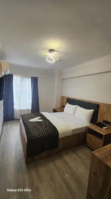 a bedroom with a large bed and a window at Hatay Hotel in Istanbul