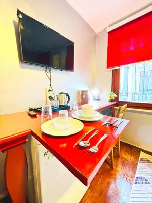 a kitchen with a table with a red counter top at Taksim Ottoman Style Hotel in Istanbul