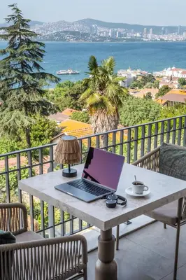 a laptop computer sitting on a table on a balcony at Hillora Hotel Buyukada in Adalar