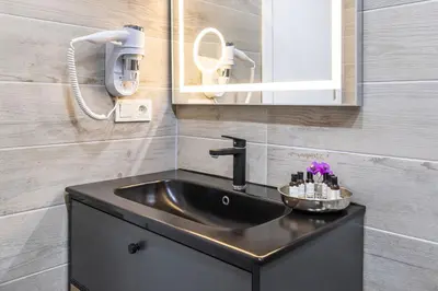 a bathroom with a black sink and a mirror at Hillora Hotel Buyukada in Adalar