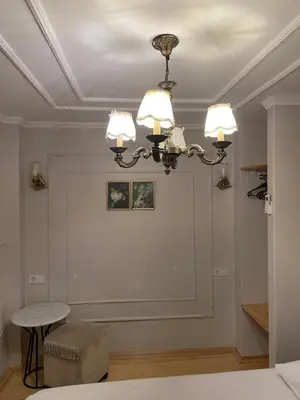 a room with a chandelier and a white wall at Balat Tarihin içinden Pink Home 1 in Istanbul