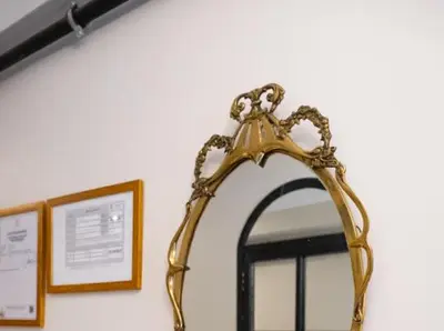 a gold mirror on a wall next to a window at Balat Tarih dokulu Pink Home 2 in Istanbul