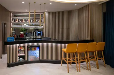 a bar in a restaurant with yellow bar stools at Hampton By Hilton Istanbul Merter in Istanbul