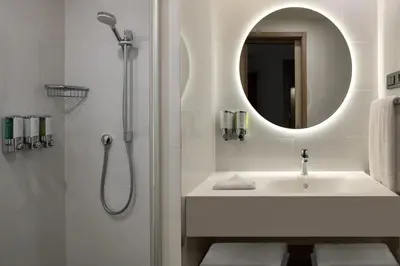 a bathroom with a sink and a shower with a mirror at Hampton By Hilton Istanbul Merter in Istanbul