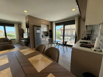 a kitchen and living room with a table and chairs at Luxurious 3BR Izmit Apartments- Mountain View in Çavuşçiftliği