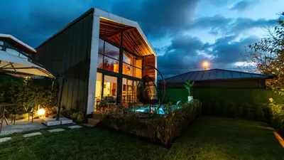 a home with a lit up backyard at night at Trio Palazio Sapanca in Sapanca
