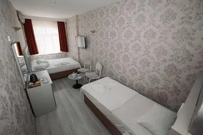 a small room with two beds and a window at Topkapi Golden Time Hotel in Istanbul