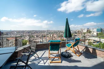 a patio with chairs and an umbrella on a roof at Urban Quarters - Loft in Istanbul