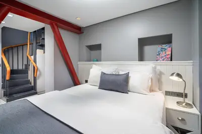 a bedroom with a white bed and a staircase at Urban Quarters - Loft in Istanbul