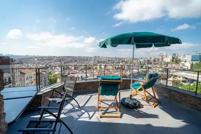 a patio with chairs and an umbrella on a roof at Urban Quarters - Loft in Istanbul