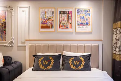 a bedroom with a bed with two pillows and posters on the wall at Fulya Süit Hotel in Istanbul