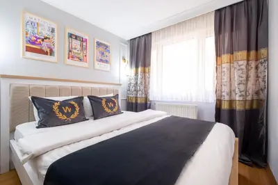 a bedroom with a large bed with black and gold pillows at Fulya Süit Hotel in Istanbul