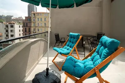 two chairs and an umbrella on a balcony with a table at Urban Quarters - Tepebaşı in Istanbul
