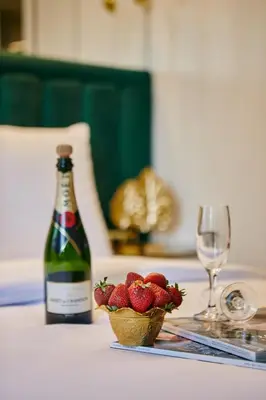 a bottle of wine and a bowl of strawberries on a table at Mitspark in Istanbul