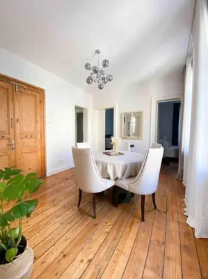 a dining room with a table and two white chairs at Charming historical apartment in Galata in Istanbul