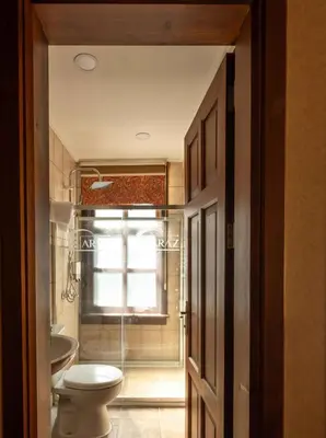 a bathroom with a toilet and a glass shower at Araz White House in Burgaz