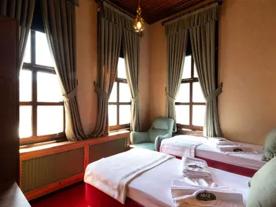a hotel room with two beds and two windows at Araz White House in Burgaz