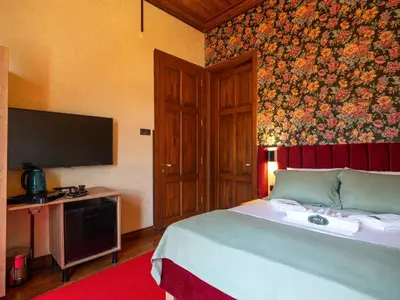 a bedroom with a bed with a tv and a wall at Araz White House in Burgaz