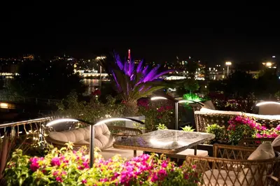 a balcony with tables and chairs and flowers at night at Gzh Park Bosphorus in Istanbul