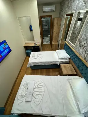 a room with two beds and a mirror at Riverside Hotel in Istanbul