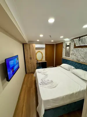 a bedroom with a bed and a tv on a wall at Riverside Hotel in Istanbul