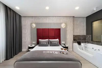 a bedroom with a large bed and a bath tub at Siesta Hotel Bakırköy in Istanbul