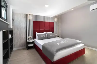 a bedroom with a large bed with a red headboard at Siesta Hotel Bakırköy in Istanbul