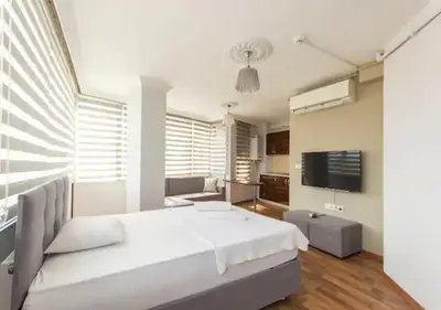 a bedroom with a white bed and a living room at Zeplin Otel in Istanbul