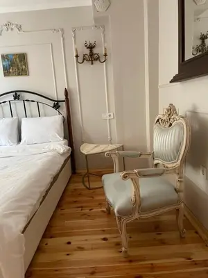 a bedroom with a bed and a chair at Fatih Balatta Pink Home 3 in Istanbul