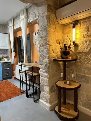 a kitchen with a stone wall with a table and chairs at MEDASUİTE Stone House With Pool And Jacuzzi in Kandıra