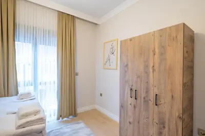 a bedroom with a large wooden cabinet next to a bed at Mayer Skycon Residence Besiktas in Istanbul