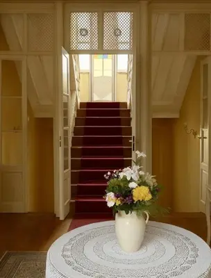 a vase of flowers on a table in a room with stairs at Anthea Butik Otel in Adalar