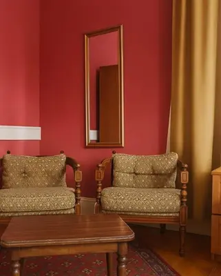a living room with two chairs and a mirror at Anthea Butik Otel in Adalar