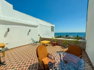 a patio with chairs and a table and the ocean at İstanbul Eagle's Nest Boutique Hotel in Istanbul