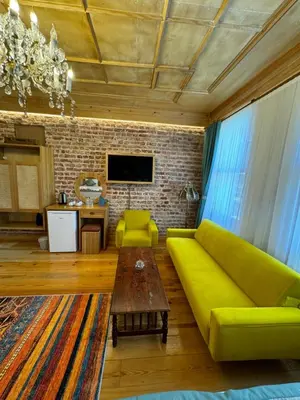 a living room with a yellow couch and a table at İstanbul Eagle's Nest Boutique Hotel in Istanbul