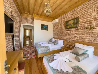 a bedroom with two beds and a brick wall at İstanbul Eagle's Nest Boutique Hotel in Istanbul