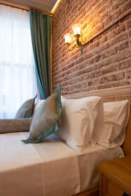 a bedroom with a brick wall and a bed with pillows at İstanbul Eagle's Nest Boutique Hotel in Istanbul