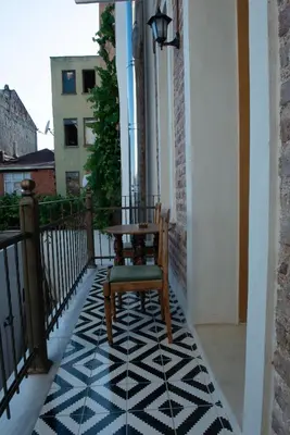 a chair on a balcony with a black and white floor at İstanbul Eagle's Nest Boutique Hotel in Istanbul