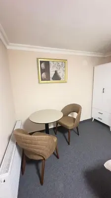 a room with a table and two chairs and a cabinet at New Hotel Harbiye in Istanbul