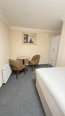 a bedroom with a bed and a table and chairs at New Hotel Harbiye in Istanbul