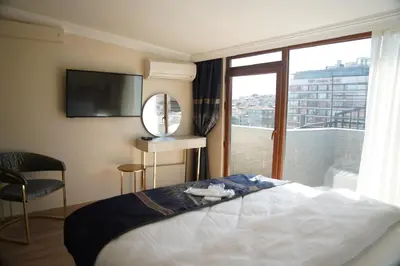 a bedroom with a bed and a large window at New Hotel Harbiye in Istanbul