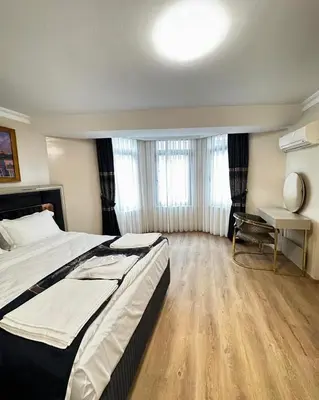 a bedroom with a large bed and a desk at New Hotel Harbiye Studio in Istanbul