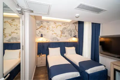 a hotel room with two beds and a tv at Querencia Hotel in Istanbul