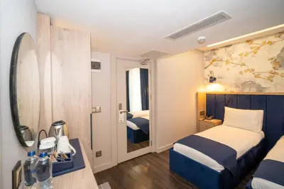 a hotel room with two beds and a mirror at Querencia Hotel in Istanbul