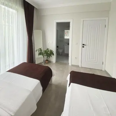 a bedroom with two beds and a bathroom with a toilet at High Garden Villas in Sapanca
