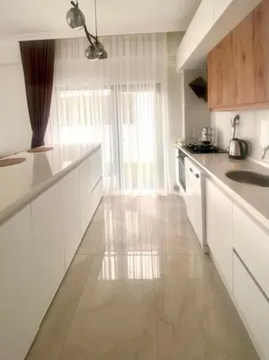 a kitchen with white cabinets and a large window at High Garden Villas in Sapanca