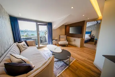 a living room with a couch and a large window at The Palm Bosphorus Hotel in Istanbul