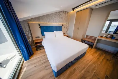 a large white bed in a room with a window at The Palm Bosphorus Hotel in Istanbul